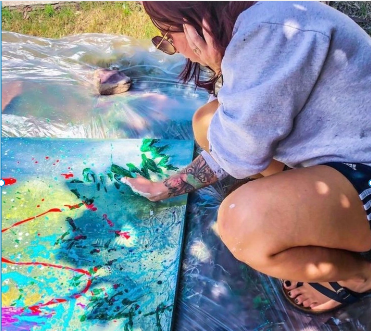 Woman painting with her hands. Tracing the shadows of a tree on a canvas. Photo by Billy Creutz